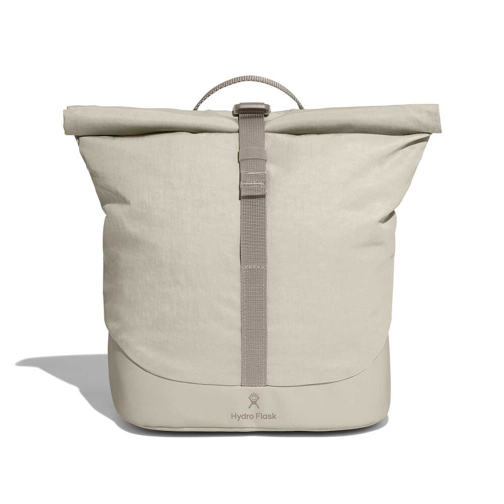 Minimalist light beige Hydro Flask roll-top backpack with central webbing strap and buckle, reinforced darker bottom, small top handle, and logo near base.