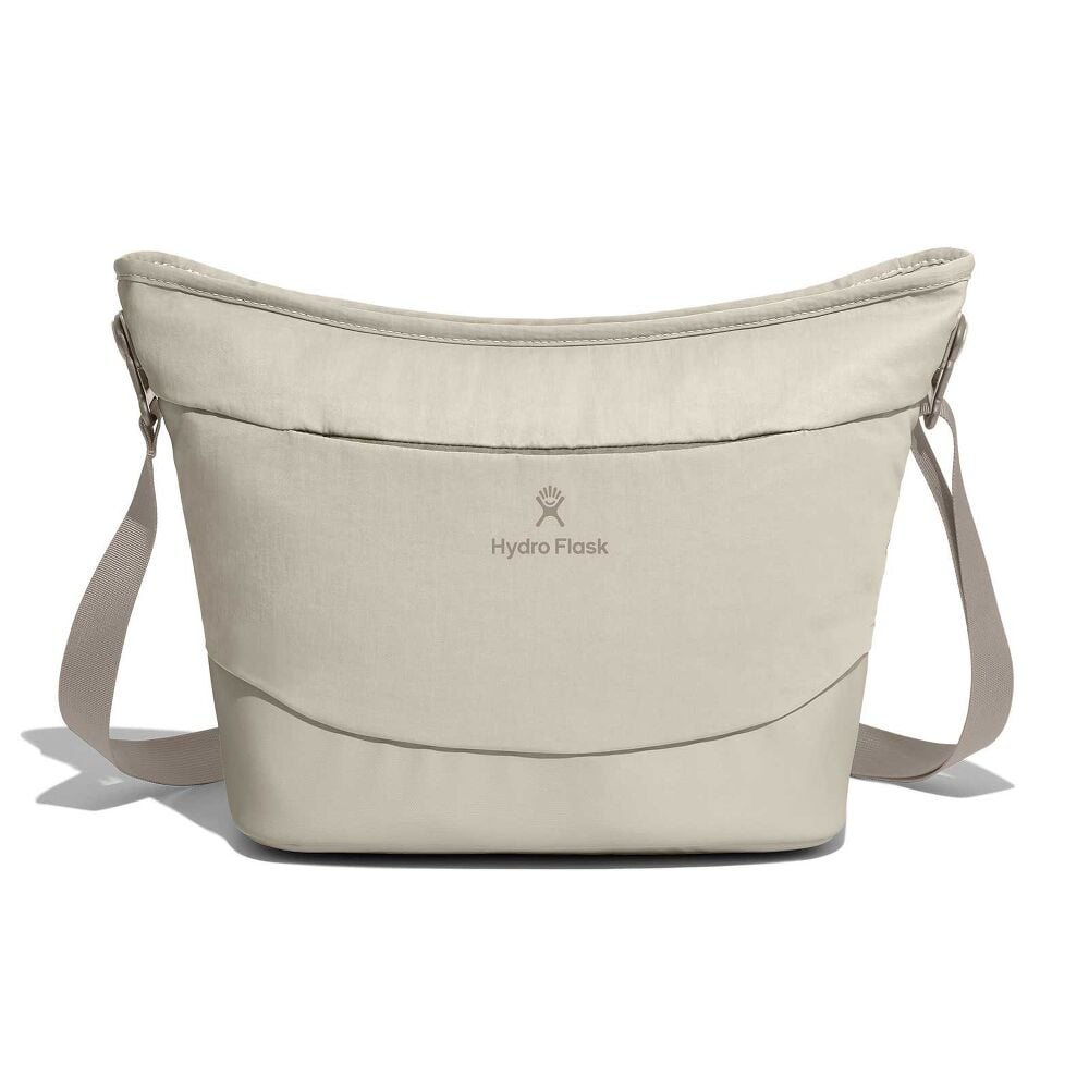 Beige Hydro Flask soft-sided cooler bag with bucket-like curved shape, adjustable straps on both sides, centered logo, and padded durable construction.