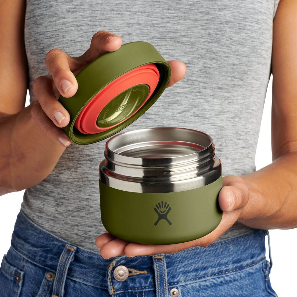 Small olive-green Hydro Flask insulated container with rounded squat shape, brushed metal band in the middle, and Hydro Flask logo on front. Matte powder-coated finish.