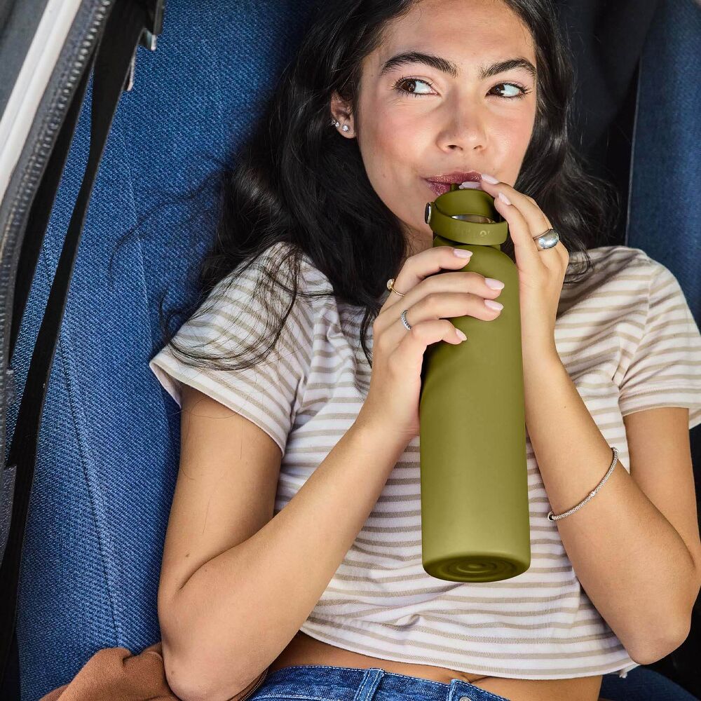 Olive-green Hydro Flask wide-mouth water bottle with powder-coated finish, screw-on lid, carry handle on metal pins, silver neck band, and logo on front.