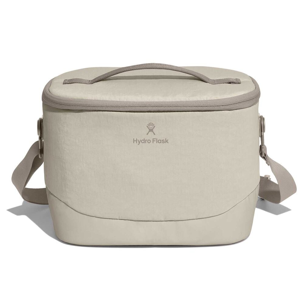 Beige Hydro Flask soft-sided cooler bag with rectangular rounded-top shape, top carry handle, full-zip lid, adjustable shoulder strap, and reinforced bottom.